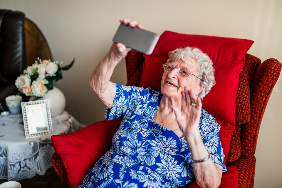 elderly woman talking on the phone with family